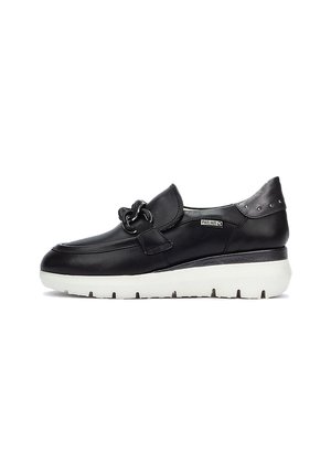 Chaussure noire en cuir à enfiler avec un accent chaîne à l'avant, semelle blanche rembourrée, forme arrondie et détails métalliques au talon.