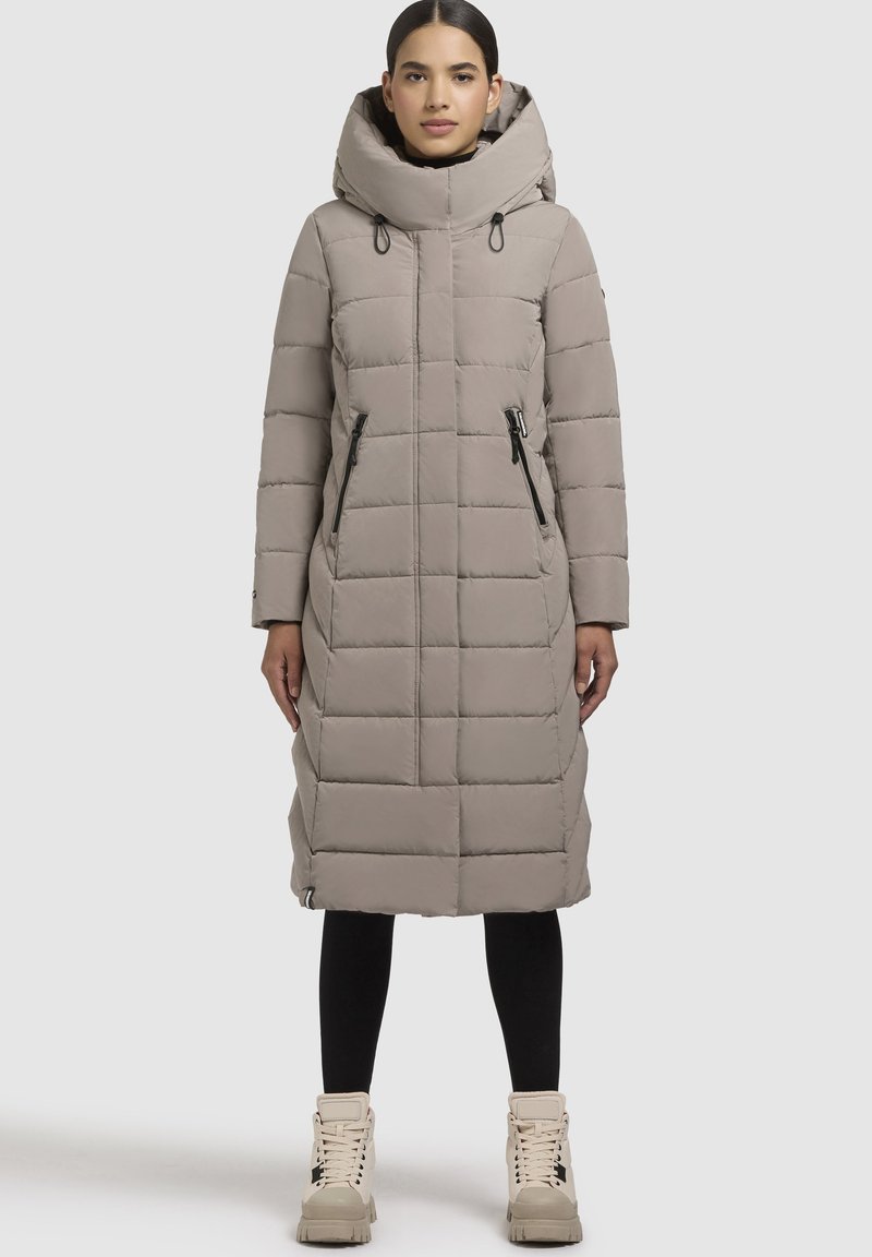 Lichtgrijze lange pufferjas met een hoge kraag, voorrits, twee zijzakken met rits, gewatteerde textuur en een relaxte pasvorm.