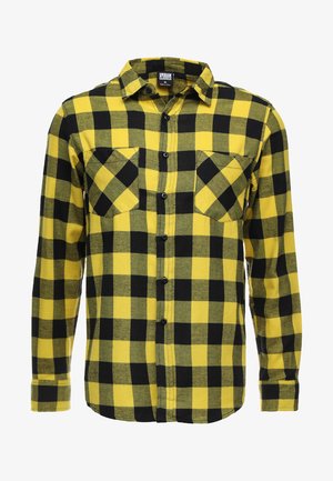Yellow and black checkered flannel shirt with long sleeves, two chest pockets, and black buttons, featuring a straight hem and soft texture.
