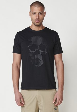 Black cotton t-shirt featuring a pixelated skull design in shades of gray, with text below in a bold font. Simple round neck, short sleeves.