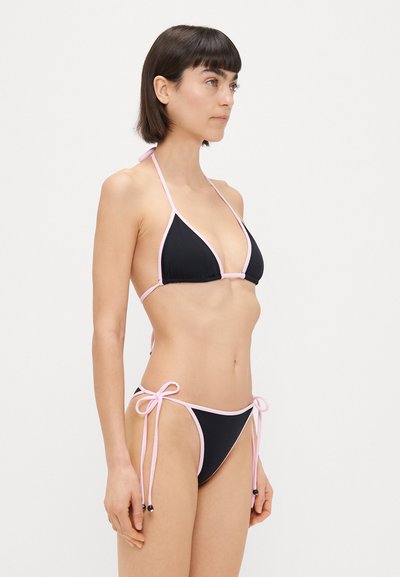 Μαύρο μπικίνι με ροζ αντίθετο φάσμα. Τρίγωνη κορυφή και ρυθμιζόμενα κορδόνια στα πλάγια. Λείος υφασμάτινος σχεδιασμός, μινιμαλιστική αισθητική και χωρίς σχέδια.