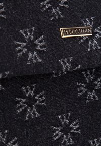 Tessuto nero con motivo di fiocchi di neve grigi, con una placca logo "WITTCHEN" in oro. Texture morbida, design minimalista e forma rettangolare.