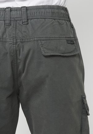 Pantaloni cargo de culoare gri închis, cu talie elastică, buzunar lateral și etichetă. Materialul are un aspect moale și texturat.