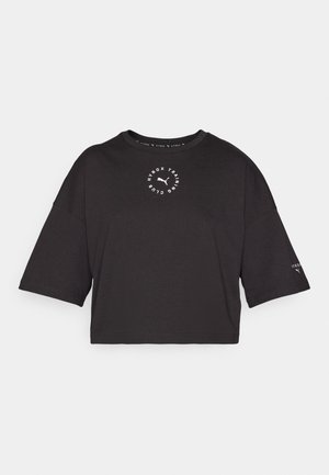 Crna skraćena majica s oversized rukavima. Sadrži okrugli bijeli logo sprijeda i male akcentne detalje na rukavima. Materijal od mješavine pamuka.