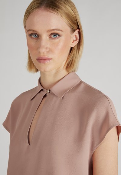 Blusa a maniche corte color malva in tessuto texturizzato con colletto abbottonato e dettaglio con scollatura a chiave. Design pulito e moderno.