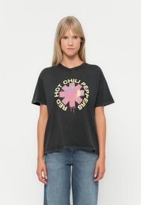 Black cotton t-shirt featuring a colorful graphic design in the center with the text "RED HOT CHILI PEPPERS" in yellow around a pink symbol.