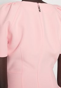 Rosa Kleid mit kurzen Puffärmeln, taillierter Form, subtilen Einsätzen und einem Reißverschluss auf der Rückseite mit "HUGC"-Hardware-Details. Glatter Stoff.