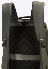 Arrière d'un sac à dos gris avec des bretelles rembourrées, un tissu en maille et un panneau noir texturé présentant un motif géométrique.