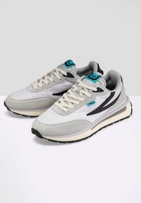 Sneakers grigio chiaro in materiali scamosciati e in rete. Presentano dettagli neri e un logo turchese. Suola intermedia spessa bianca e suola esterna nera testurizzata.
