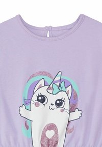 Vestido de algodón morado con un gráfico de personaje que incluye un cuerno de unicornio brillante, un lazo y un corazón, sobre un fondo de patrones en tonos pastel.