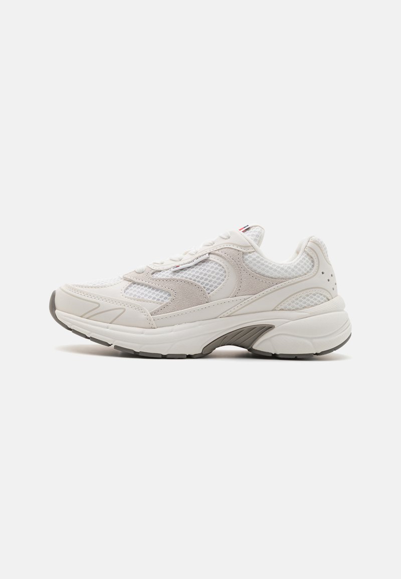 Białe sneakersy z siateczkową cholewką i zamszowymi akcentami, z grubą podeszwą oraz teksturowanym wzorem. Zawierają sznurowadła i subtelne detale logo.