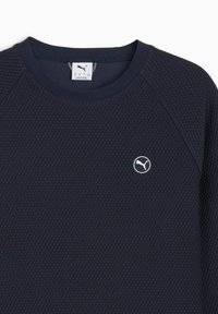 Sudadera de color azul oscuro hecha de tejido texturizado, con cuello redondo, mangas raglán y un pequeño logo blanco de Puma en el pecho.