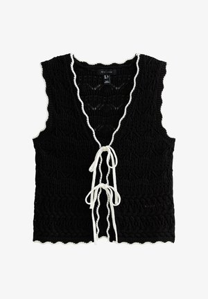 Black crocheted sleeveless vest with white scalloped trim and two white tie closures on the front.