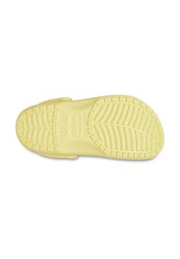 Semelle de sandale en caoutchouc jaune avec des motifs de traction texturés, deux trous latéraux et un logo en relief. Elle présente des sangles larges et un bout arrondi.