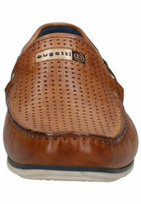 Scarpa in pelle perforata marrone, con punta arrotondata, fodera blu a contrasto e una piccola etichetta logo sulla tomaia. Suola piatta in gomma.