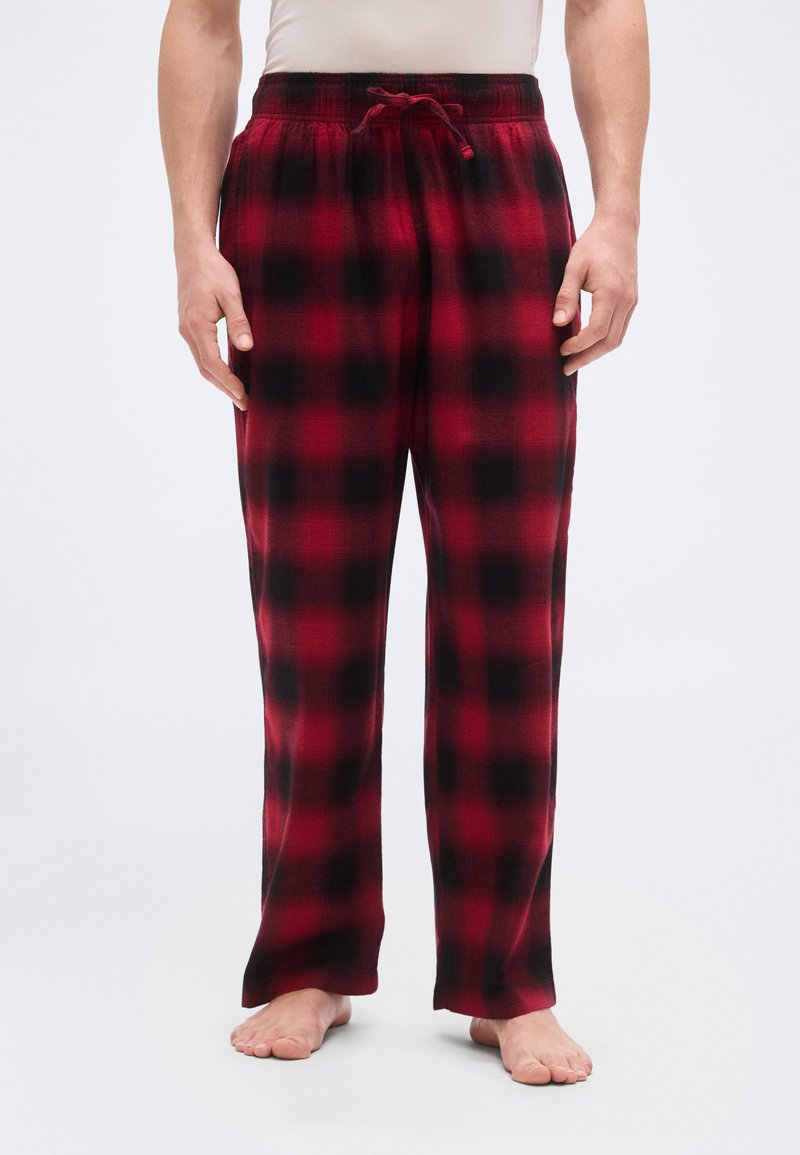 Pantalon de pyjama en flanelle à carreaux rouges et noirs avec taille élastique et cordon de serrage ajustable, présentant une coupe décontractée et une texture douce.