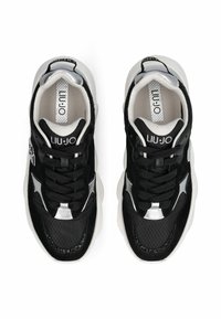 Baskets noires et blanches avec une tige texturée, fermeture à lacets et accents métalliques. Dotées d'une semelle rembourrée et de détails avec logo.