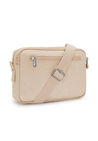 Beige fabric crossbody bag with a rectangular shape, smooth texture, adjustable strap, and front zip pocket with silver hardware.