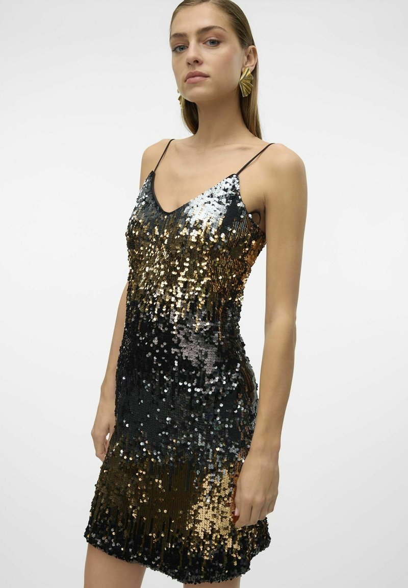 Sukienka z cekinów z gradientem srebra, złota i czerni, z cienkimi ramiączkami i dopasowaną sylwetką. Teksturowana powierzchnia z refleksyjnymi akcentami.