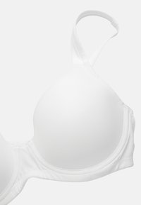Weißer BH mit weichen, vorgeformten Cups, dünnen verstellbaren Trägern und nahtlosen Kanten. Aus glattem Stoff mit einer leicht matten Textur hergestellt.
