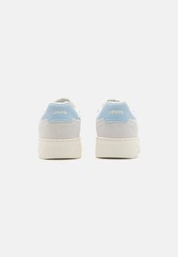 Hvite og lyseblå sneakers med en blanding av semsket skinn og syntetisk materiale, med en polstret såle og "Levi's"-logoen på hælen.