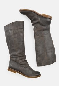 Stivali alti in pelle grigia con un design morbido, suola piatta color tan e dettagli di cucitura marrone discreti. Tessitura liscia, punta affusolata.
