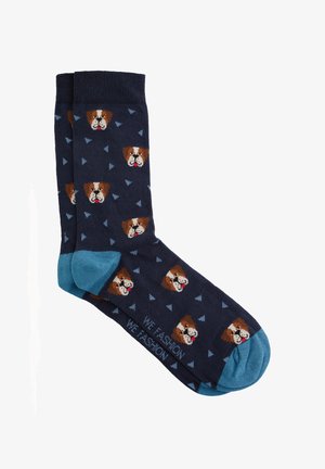 Chaussettes bleu marine avec des orteils et des poignets bleu clair, décorées de petits visages de chien et de motifs triangulaires bleus.