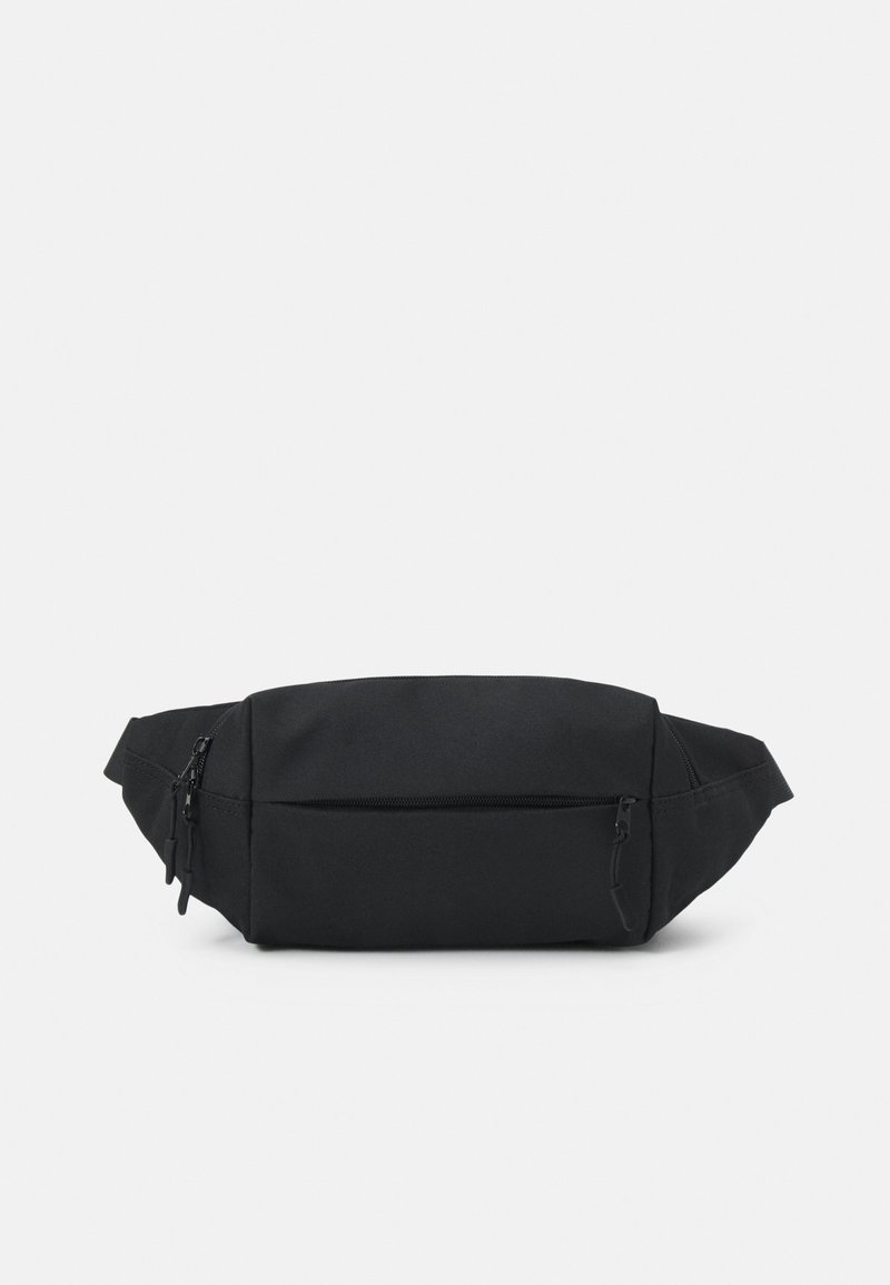 Sac banane en tissu noir avec trois compartiments zippés et une sangle réglable, conçu pour un port mains libres.