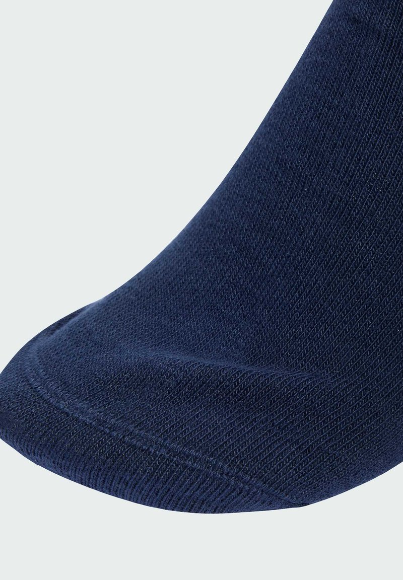 Navyblå sok med ribbet struktur og glat tå-søm. Har forstærket hæl og elastisk kant for en tætsiddende pasform.