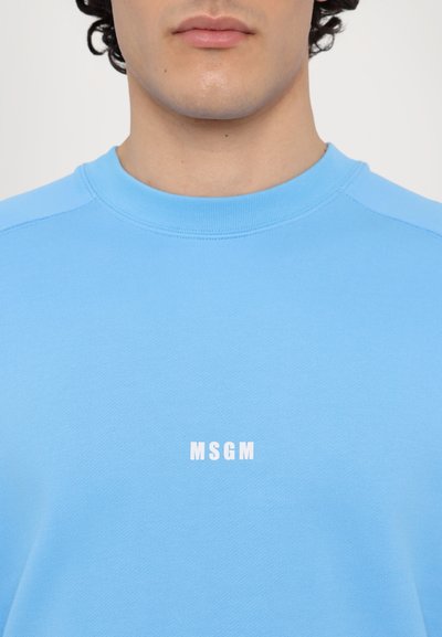 Sudadera azul claro hecha de suave tela de algodón. Presenta un escote redondo y un logo impreso en blanco "MSGM" en la parte delantera.