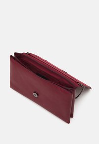 Portefeuille en cuir rouge au toucher lisse, doté d'une fermeture à bouton et de plusieurs compartiments, ouvert pour révéler l'intérieur.