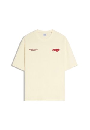Cream-colored short-sleeve T-shirt with red text "WEARABLE ARTIFACTS SINCE 1998" on left chest and stylized "mg" logo on right chest.