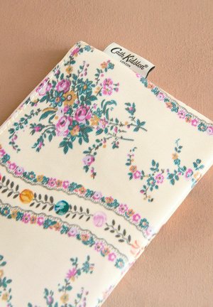 Floral-patterned wallet in cream, featuring colorful flowers, leaves, and decorative borders. Made of textured fabric with a stitched label.