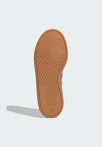 Gumeni đonovi cipele s uzorkom u obliku dijamanta u boji trna, s utisnutim logotipom na peti. Ravan, ovalni oblik s zaobljenim rubovima.