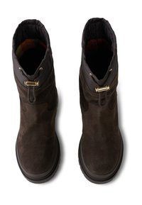 Czekoladowe zamszowe botki za kostkę z czarnymi tekstylnymi mankietami. Zawierają złote akcenty oraz grubą podeszwę. Gładka powierzchnia z detalami w postaci wyraźnych szwów.