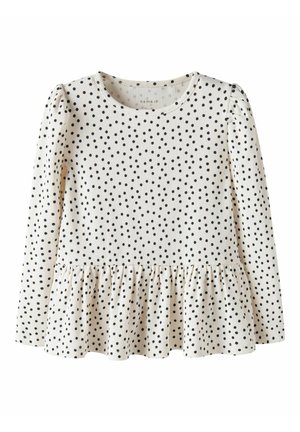 Haut blanc à manches longues pour enfants avec des pois noirs, col rond, léger effet bouffant aux épaules et ourlet à basque volanté.
