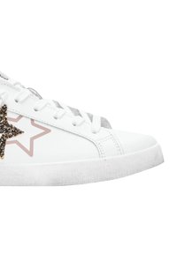 Sneaker bianco con lacci bianchi, una piccola stella dorata glitterata sopra una sagoma di stella beige sul lato, e bordi della suola leggermente usurati.