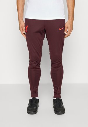 Bordeauxfarbene Sporthosen mit slim fit, ausgestattet mit einem roten Nike-Logo und dem Wappen des Liverpool FC. Glattes Material und elastischer Bund.