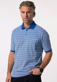 Blå polo med vita ränder, korta ärmar och en bl å krage. Har tre knappar och en liten bröstficka. Mjuk textur.