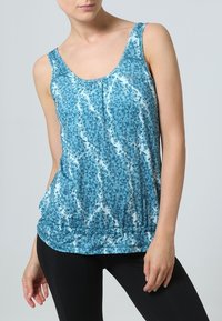 Haut débardeur bleu avec un motif géométrique, doté d'un décolleté en rond, d'une coupe sans manches et d'un ourlet élastiqué froncé. Tissu lisse et léger.