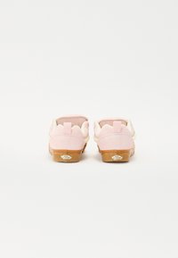 Rózsaszín velúr slip-on cipők világos krémszínű körülfutó kiegészítővel a saroknál, és texturált gumitalppal; hátul egy logólemez található.