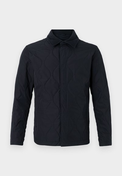 Melnā kvadrātveida jaka ar apkakli, ar gludu virsmu, teksturētu viļņotu rakstu un šauru piegriezumu. Priekšējie pogas ir paslēptas.