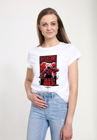 Bílá tričko s grafikou Červeného Hulka, odvážné černé a červené barvy. Design obsahuje stylizovaný text a dynamickou pózu.
