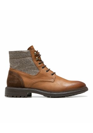 Bottes de cheville en cuir marron avec un dessus en tissu marron texturé, bout rond, devant à lacets, et une semelle en caoutchouc dotée de rainures pour une meilleure adhérence.
