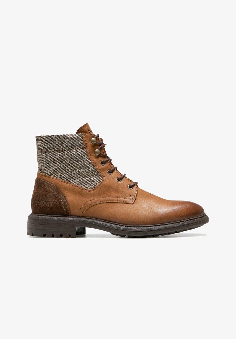Bottes de cheville en cuir marron avec un dessus en tissu marron texturé, bout rond, devant à lacets, et une semelle en caoutchouc dotée de rainures pour une meilleure adhérence.