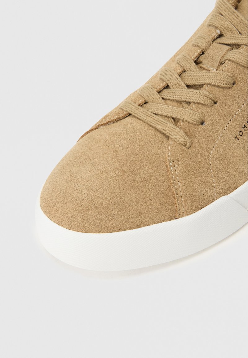 Wildleder-braune Sneaker mit runder Zehenkappe, weißer Gummisohle und passenden Schnürsenkeln. Verfügt über gestickte Akzente und eine strukturierte Oberfläche.