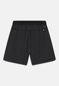 Schwarze Sportshorts aus weichem, feuchtigkeitsableitendem Stoff mit elastischem Bund und einem kleinen Logolabel auf der Rückseite.