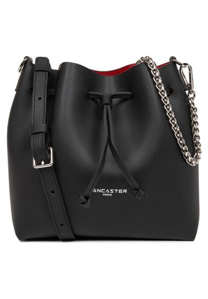 Sac seau en cuir noir avec une fermeture à cordon, accent en chaîne argentée et intérieur rouge. Doté d'une bandoulière réglable et d'un détail de logo.