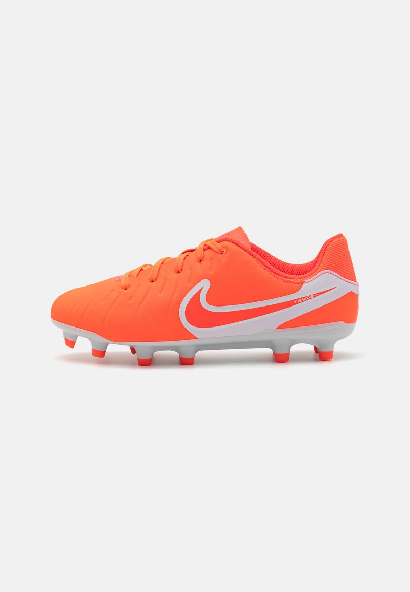 Lyse orange fotballsko med teksturert overdel, grå såle, hvit swoosh-logo og runde pigger for grep på gressflater.