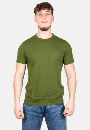 T-shirt in cotone verde oliva con maniche corte, colletto rotondo e taschino sul petto con un piccolo logo blu. Vestibilità casual, texture liscia.